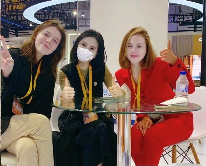 Diva with colleagues at an exhibition booth.